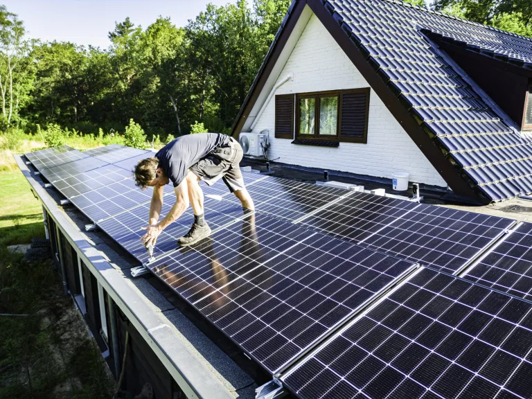Monteur monteert een zonnepaneel op een plat dak