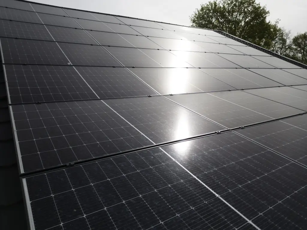 Zonnepanelen op een dak met de zon erin weerspiegeld